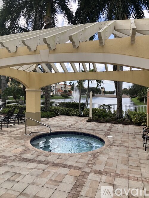 A pool area with a white pergola and a small pool.