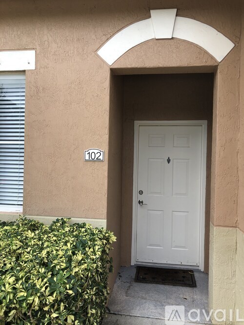 A white door with a black handle is on the right side of a beige wall.