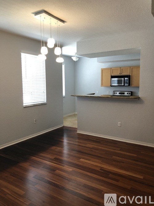A room with wooden floors and a small kitchenette.