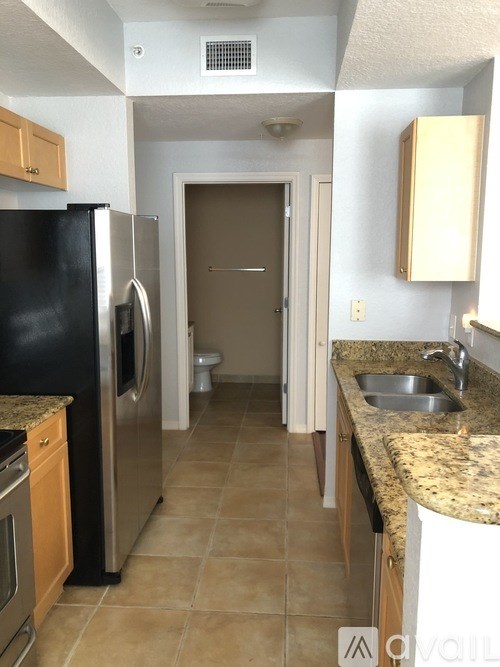 A kitchen with a black fridge and a sink.
