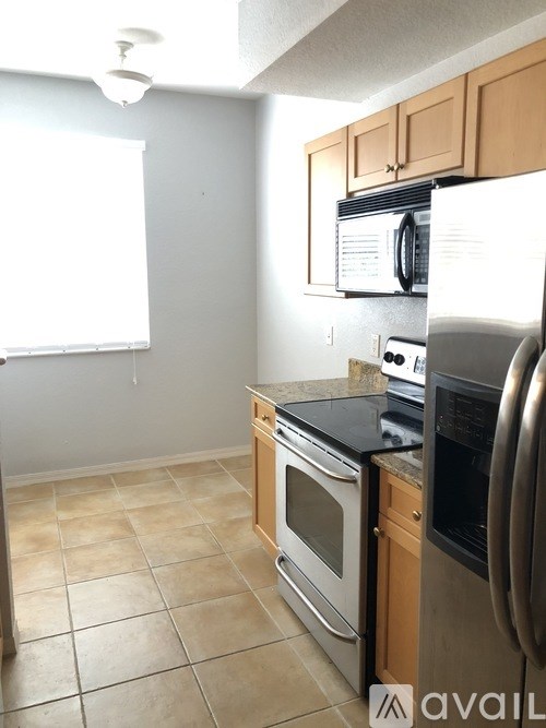 A kitchen with a black counter top and stainless steel appliances.