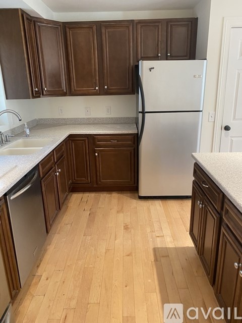 A kitchen with wooden cabinets and a white fridge.