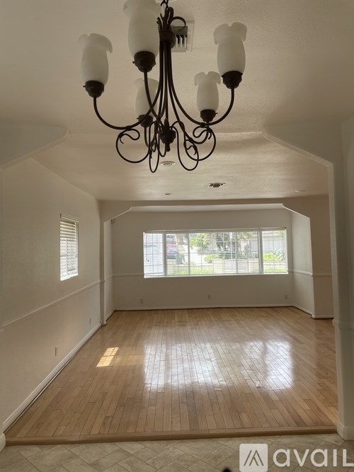 A room with wooden floors and a chandelier.