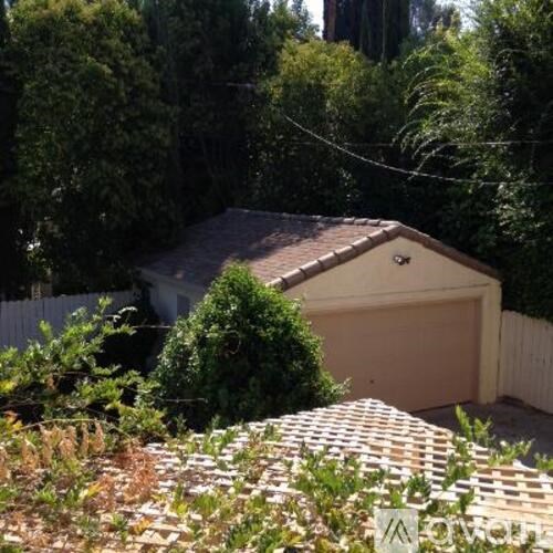 A backyard with a brick wall and a garage.