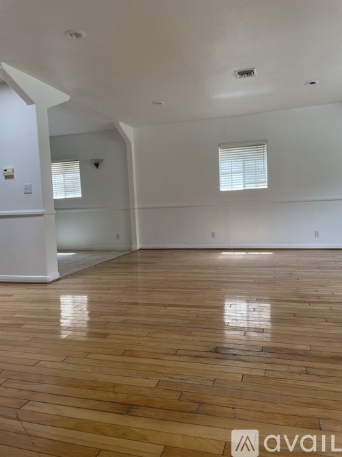 A room with wooden flooring and white walls.