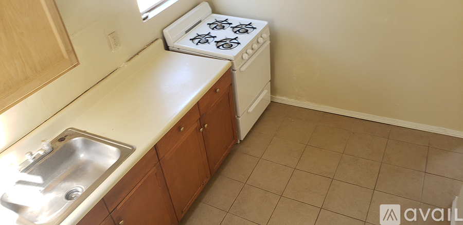 A kitchen with a stove top oven and a sink.