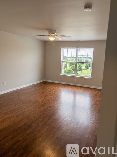 A room with wooden flooring and a ceiling fan.