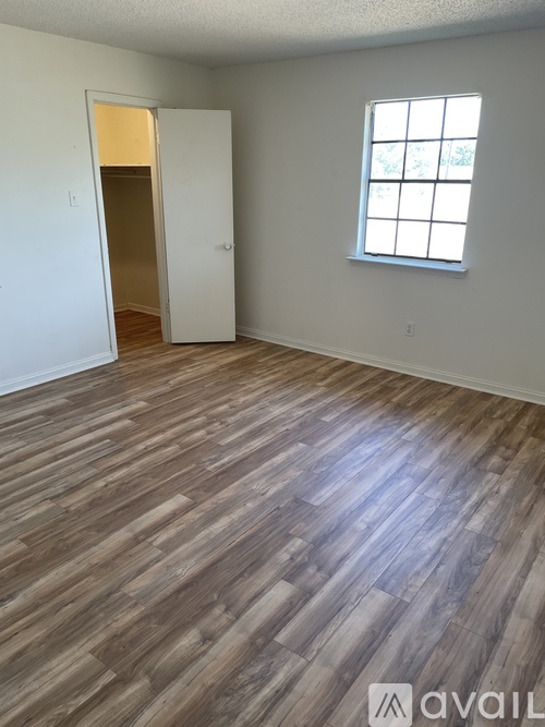A room with wooden flooring and a window.