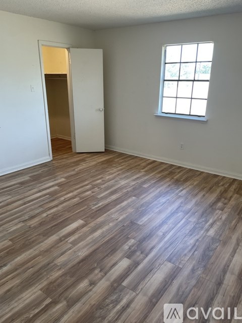 A room with wooden flooring and a window.