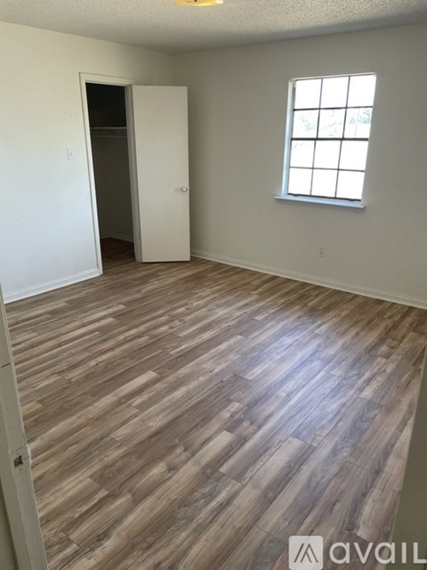 A room with wooden flooring and a window.
