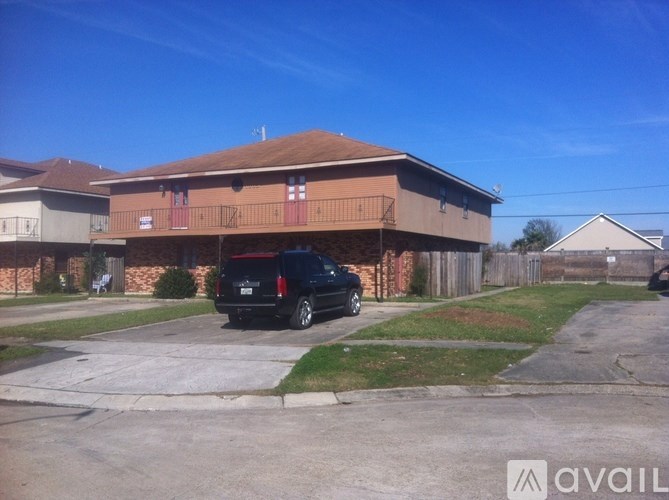 A black SUV is parked in front of a two-story building.