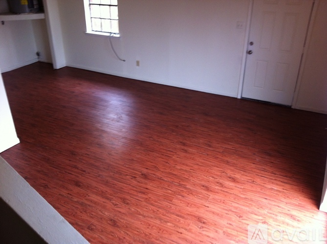 A room with a wooden floor and a white door.