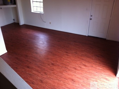 A room with a wooden floor and a white door.