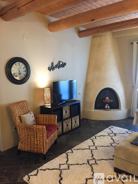 A living room with a sofa, chair, and fireplace.
