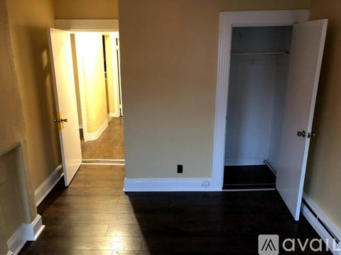 A hallway with two doors on either side and a third door at the end.