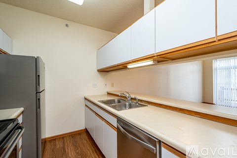 A kitchen with white cabinets and a wooden counter top.