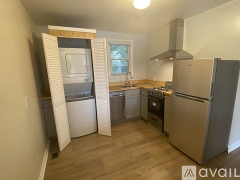 A kitchen with a refrigerator, oven, and sink.