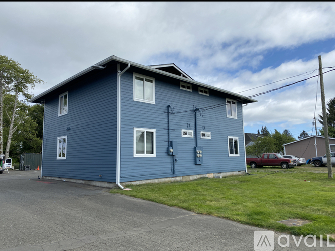 A blue house with a car parked in front.