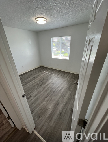 A room with wooden flooring and a window.
