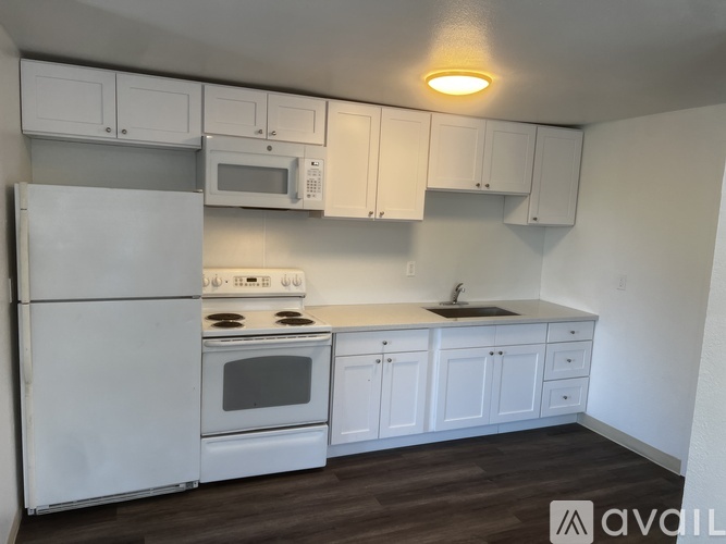 A kitchen with white appliances and cabinets.