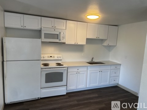 A kitchen with white appliances and cabinets.