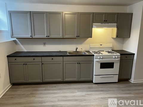 A kitchen with a white stove top oven and a black counter top.