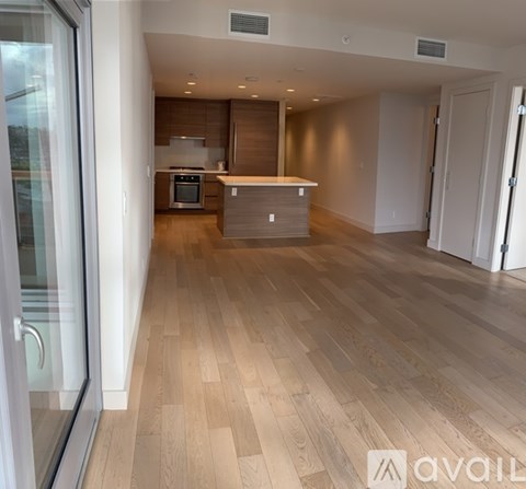 A spacious kitchen with wooden flooring and a modern design.