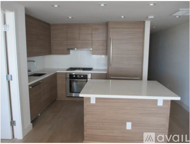 A kitchen with a white countertop and wooden cabinets.