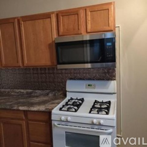 A white gas stove with a microwave above it in a kitchen.