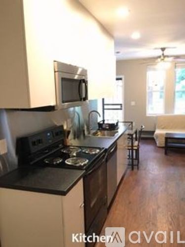 A kitchen with black countertops and white cabinets.