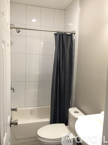 A white toilet sits next to a bathtub in a bathroom.