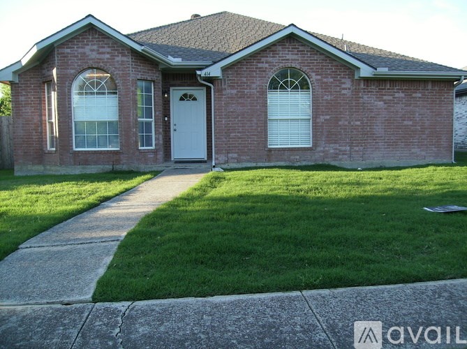 A brick house with a white door and windows.