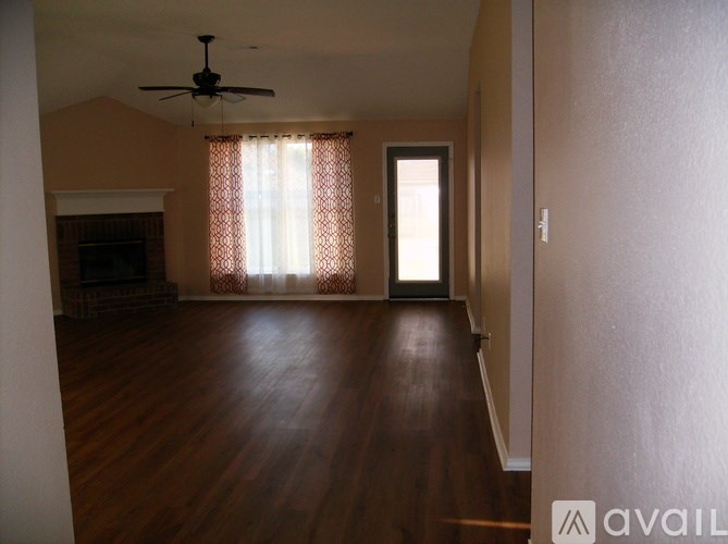 A room with a fireplace and a ceiling fan.
