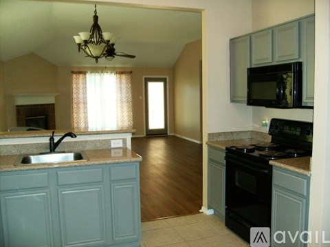 A kitchen with a sink, stove, and microwave.