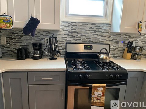 A kitchen with a black stove top oven and a white counter top.
