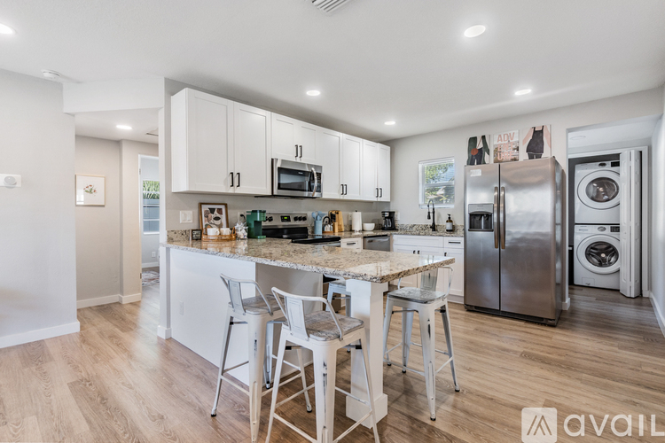 A kitchen with white cabinets and a granite countertop.