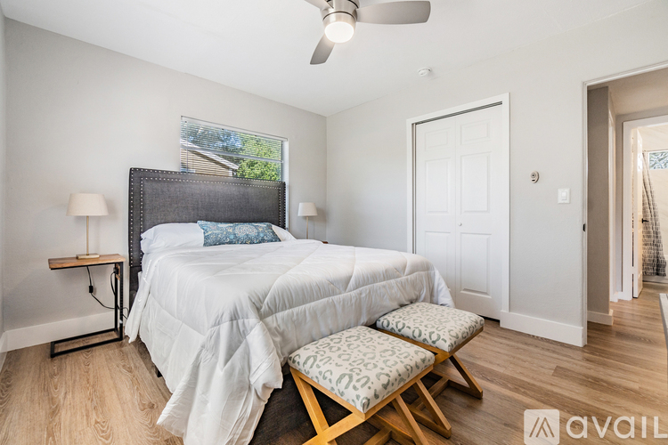 A bedroom with a large bed and a ceiling fan.
