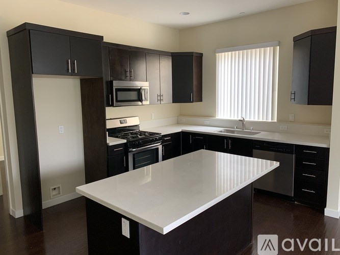 A kitchen with a white countertop and black cabinets.