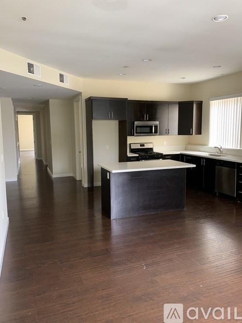 A kitchen with a black counter top and a microwave above the stove.