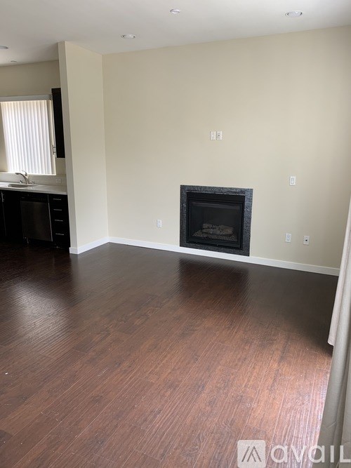 A living room with a fireplace and wood flooring.