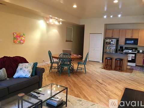 A living room with a grey couch and a glass coffee table.