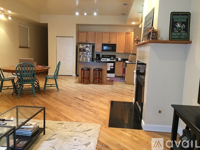 A kitchen with wooden floors and a dining table with chairs.