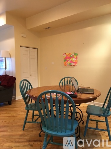 A dining room with a table surrounded by chairs.