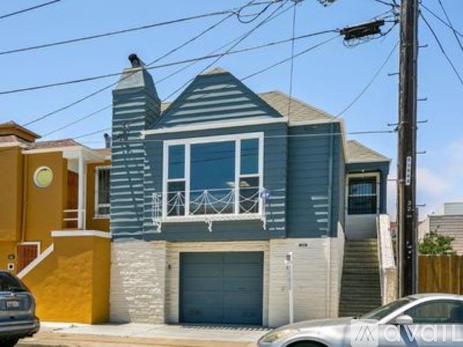 A two-story house with a garage on the ground floor and a balcony on the second floor.