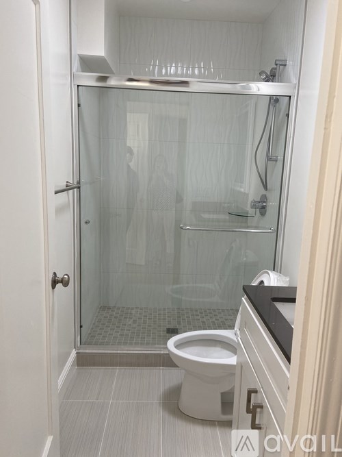 A bathroom with a toilet, sink, and shower.