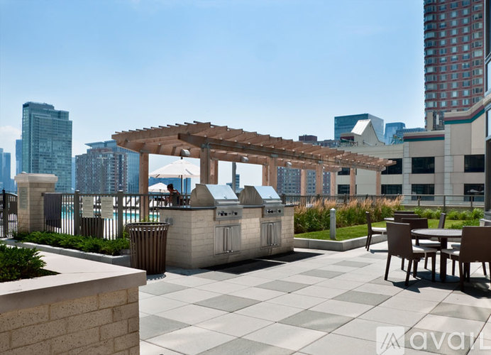 A patio with a table and chairs and a grill.