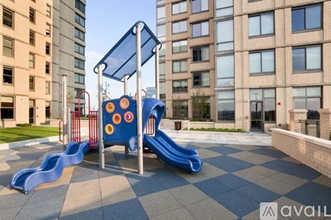 A playground with a blue slide and a red and yellow structure.