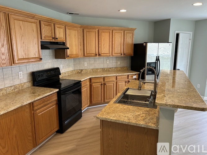 A kitchen with wooden cabinets and a black stove top oven.