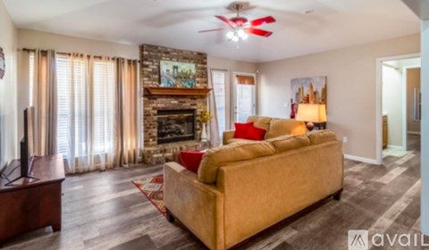 A living room with a couch, television, and fireplace.