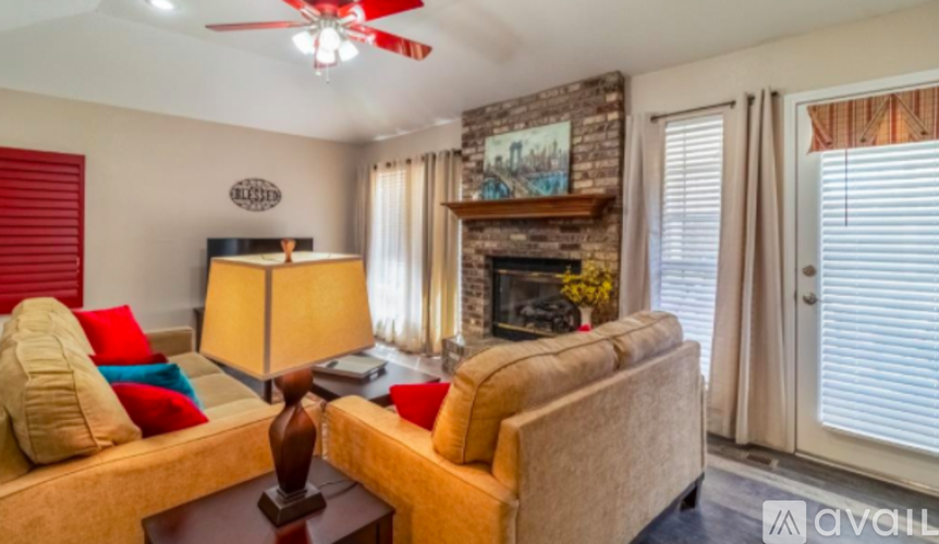 A living room with a couch, a lamp, and a fireplace.